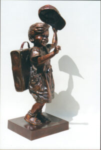 bronze sculpture of a child holding up a baseball cap
