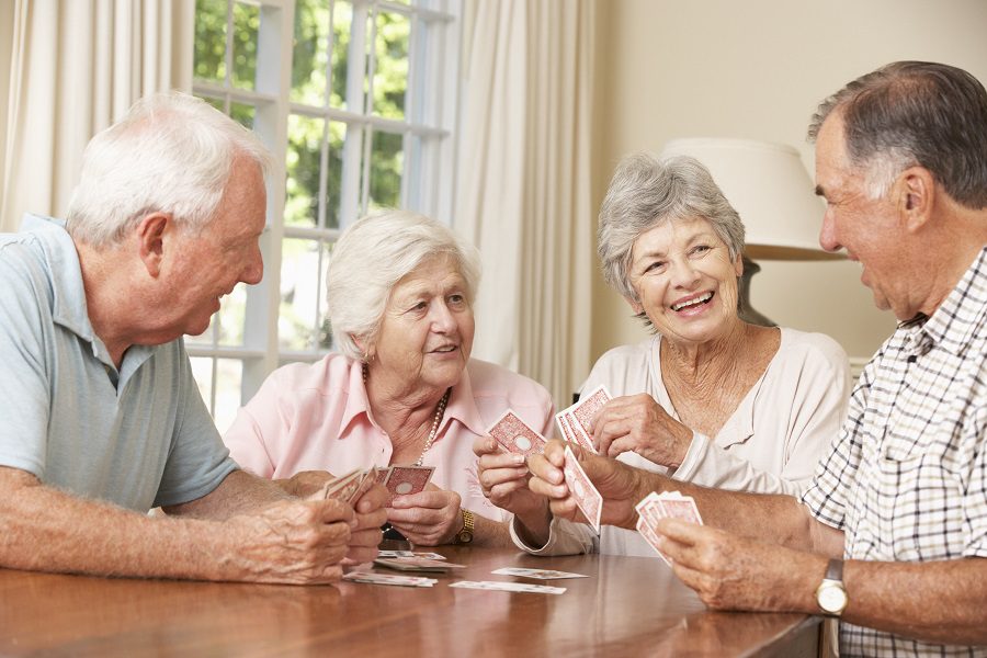Group of seniors playing cards indoors