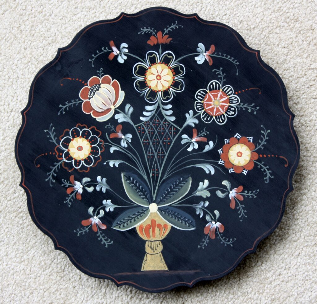 A painted plate done in rosemaling style.